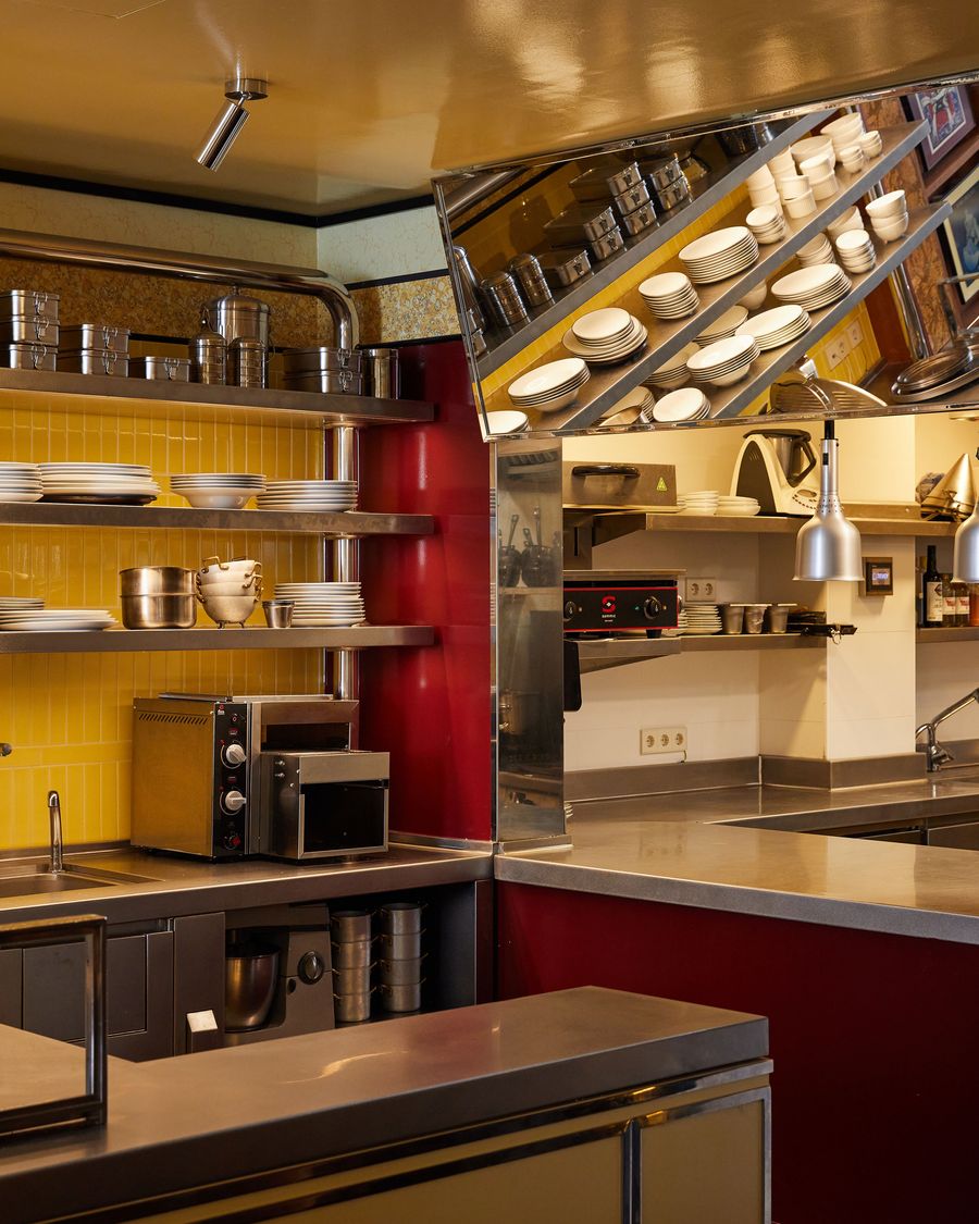 A dynamic, multi-angled view of a kitchen space. The industrial aesthetic is defined by stainless steel surfaces and open shelving, while a high-gloss red panel and a dramatic, slanted mirror add a bold, deconstructed, and unexpectedly artistic element to the functional design. A dynamic, multi-angled view of a kitchen space. The industrial aesthetic is defined by stainless steel surfaces and open shelving, while a high-gloss red panel and a dramatic, slanted mirror add a bold, deconstructed, and unexpectedly artistic element to the functional design.