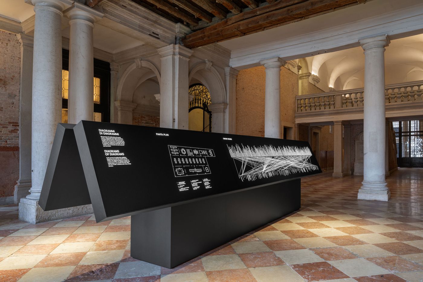 An artistic display featuring sleek diagrams in a historic room with marble columns and tiled flooring. An artistic display featuring sleek diagrams in a historic room with marble columns and tiled flooring.