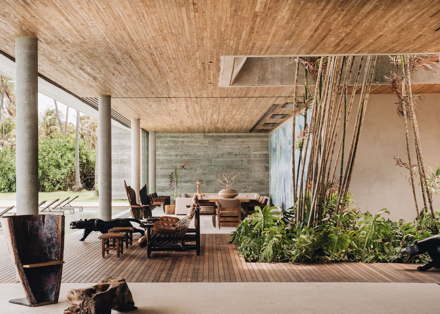 Stylish modern interior featuring wooden flooring, plants, and artistic decor, offering a serene, open atmosphere with natural light.