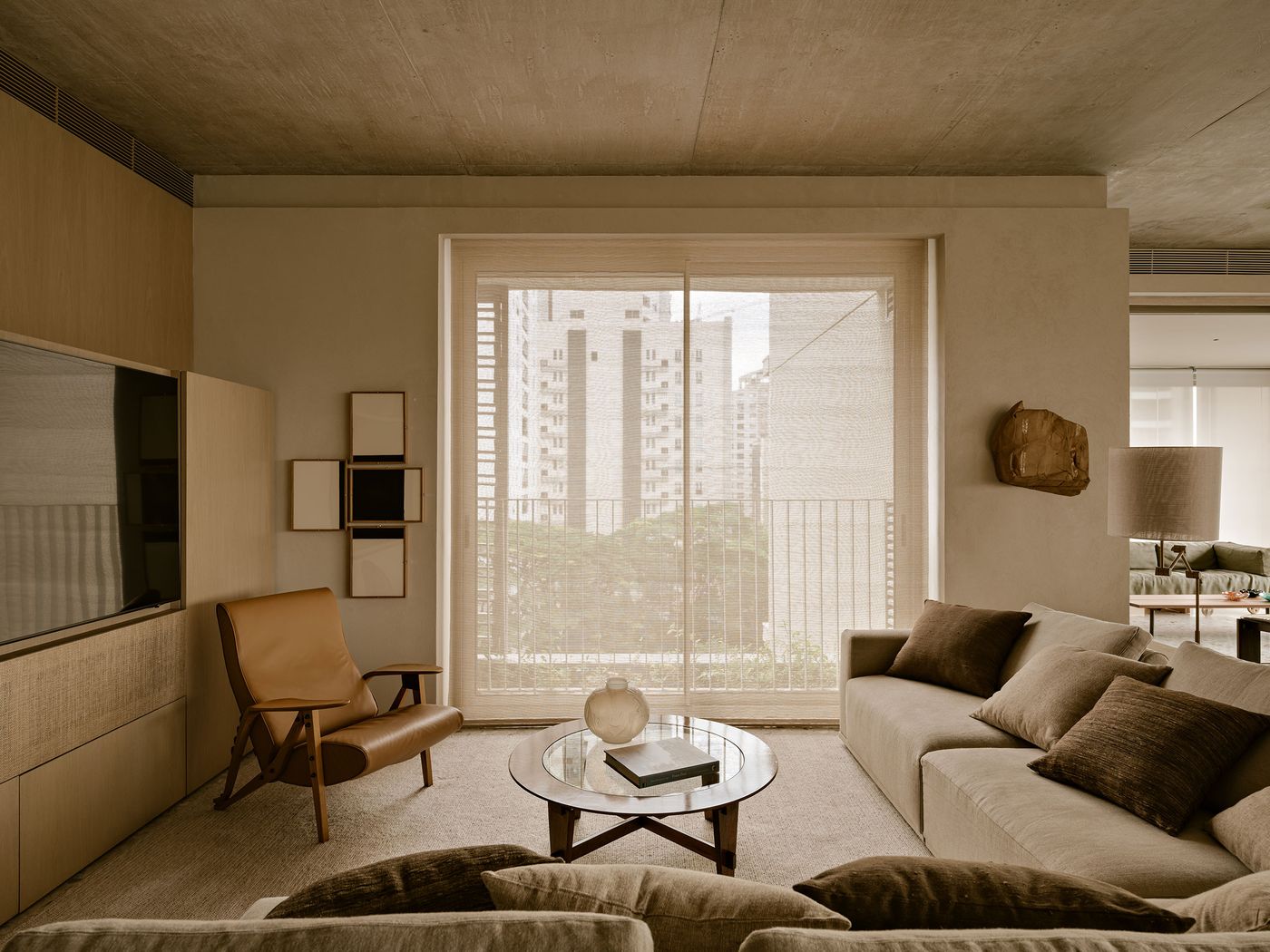 Modern living room featuring a beige sofa, a brown leather chair, and large windows with city views, creating a warm, inviting atmosphere. Modern living room featuring a beige sofa, a brown leather chair, and large windows with city views, creating a warm, inviting atmosphere.