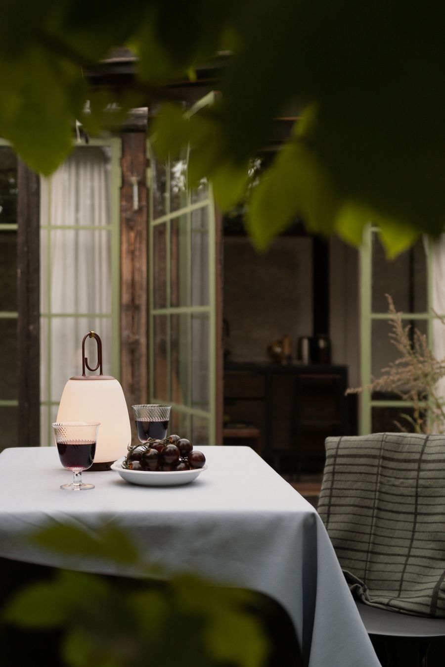 Twilight dinner framed by nature—portable glow, cut glass, and deep-hued grapes conjure quiet sophistication. Twilight dinner framed by nature—portable glow, cut glass, and deep-hued grapes conjure quiet sophistication.