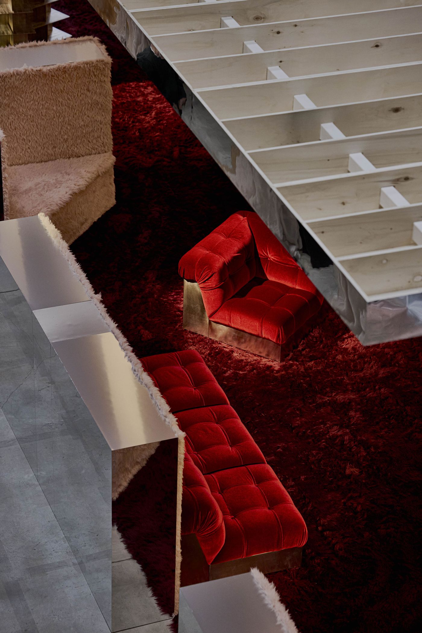 Tufted red velvet seats nestle in a corridor of shag and sheen—a velvet underground for design lovers. Tufted red velvet seats nestle in a corridor of shag and sheen—a velvet underground for design lovers.