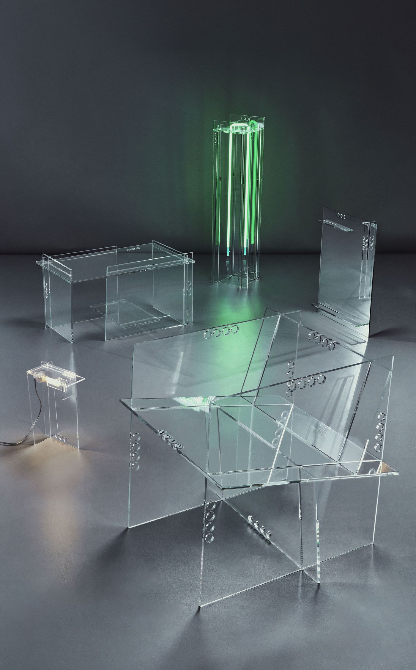 A poetic gathering of acrylic furniture pieces under soft light, including a green glowing light sculpture.