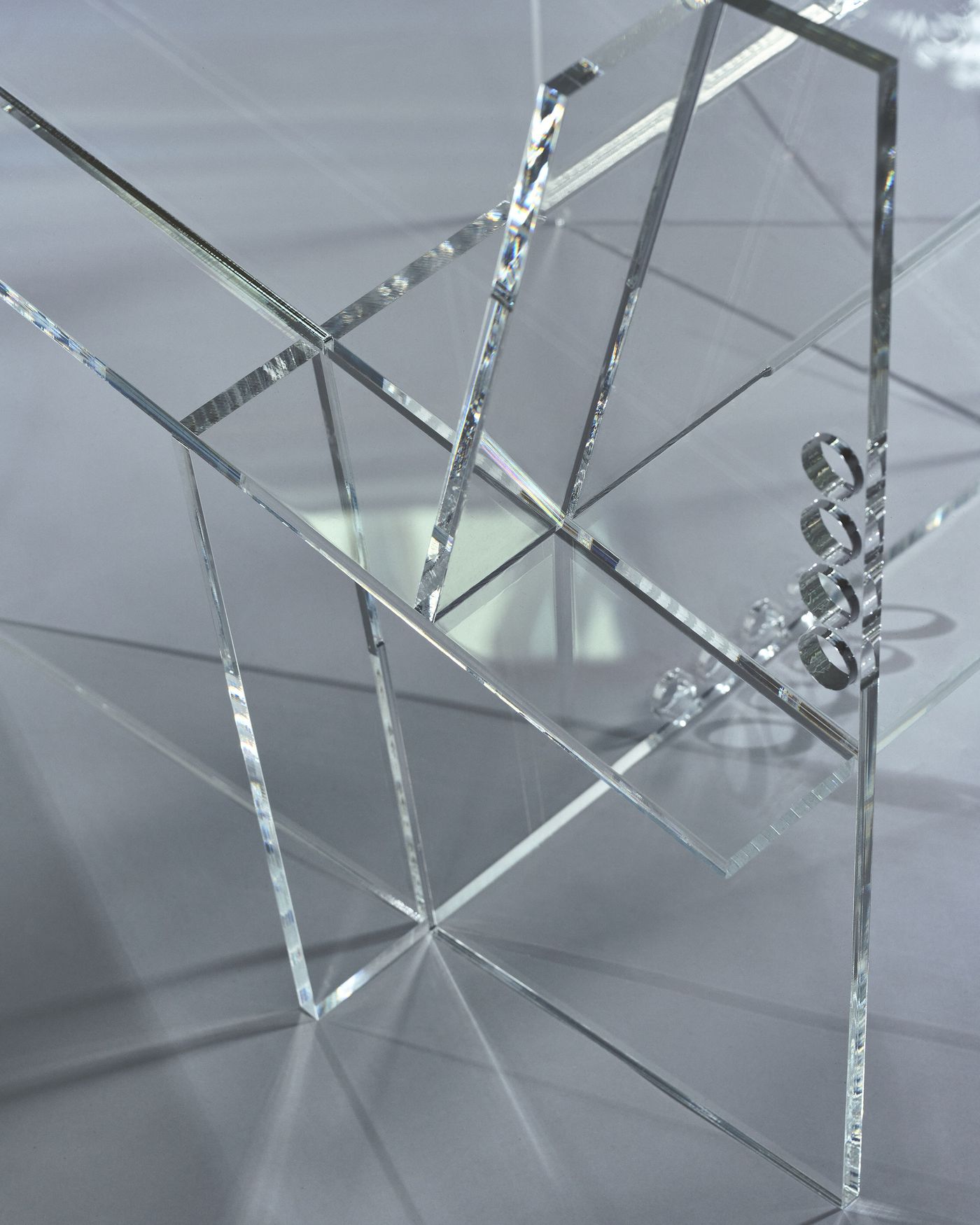 Detail shot of intersecting acrylic planes revealing prismatic edges and dotted connection points.