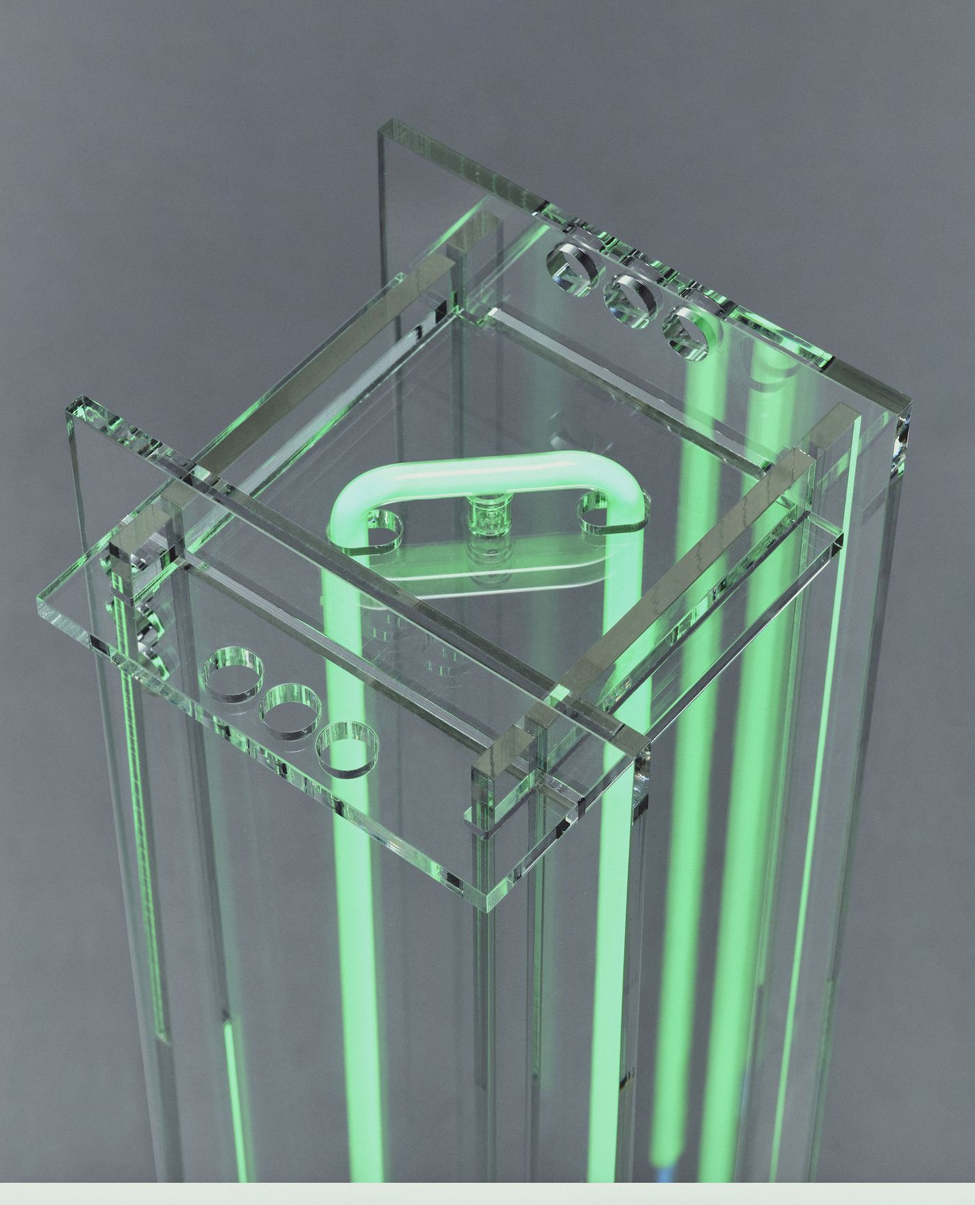 Close-up of the lamp’s top structure—crisp edges, drilled circles, and glowing neon green energy.