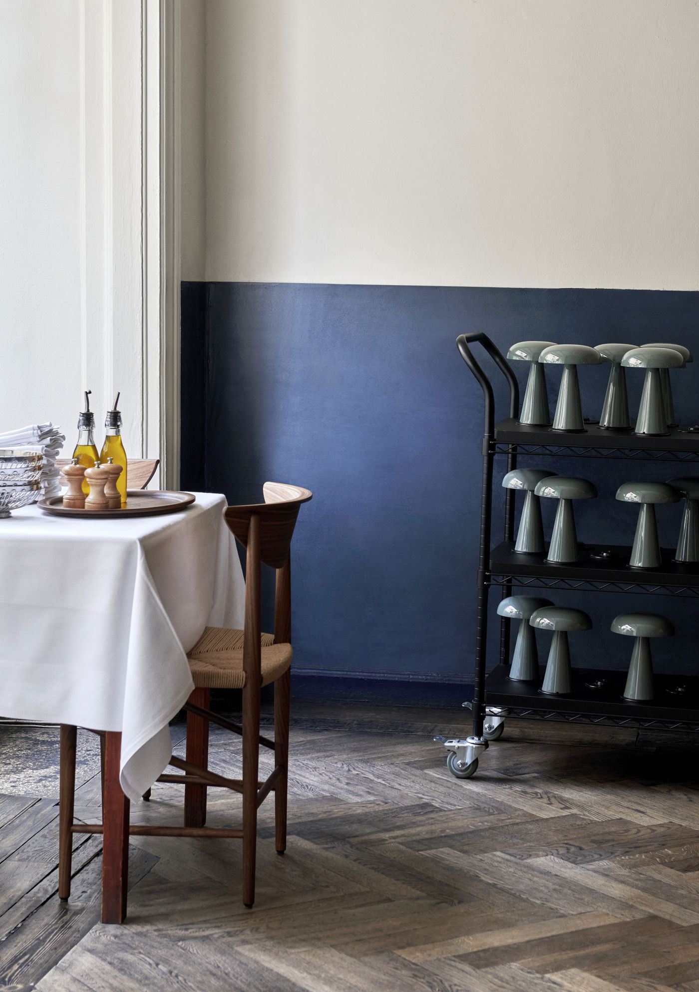 A stylish restaurant corner with a charging trolley full of glossy Como lamps by &Tradition, ready to light up every table with sculptural charm.