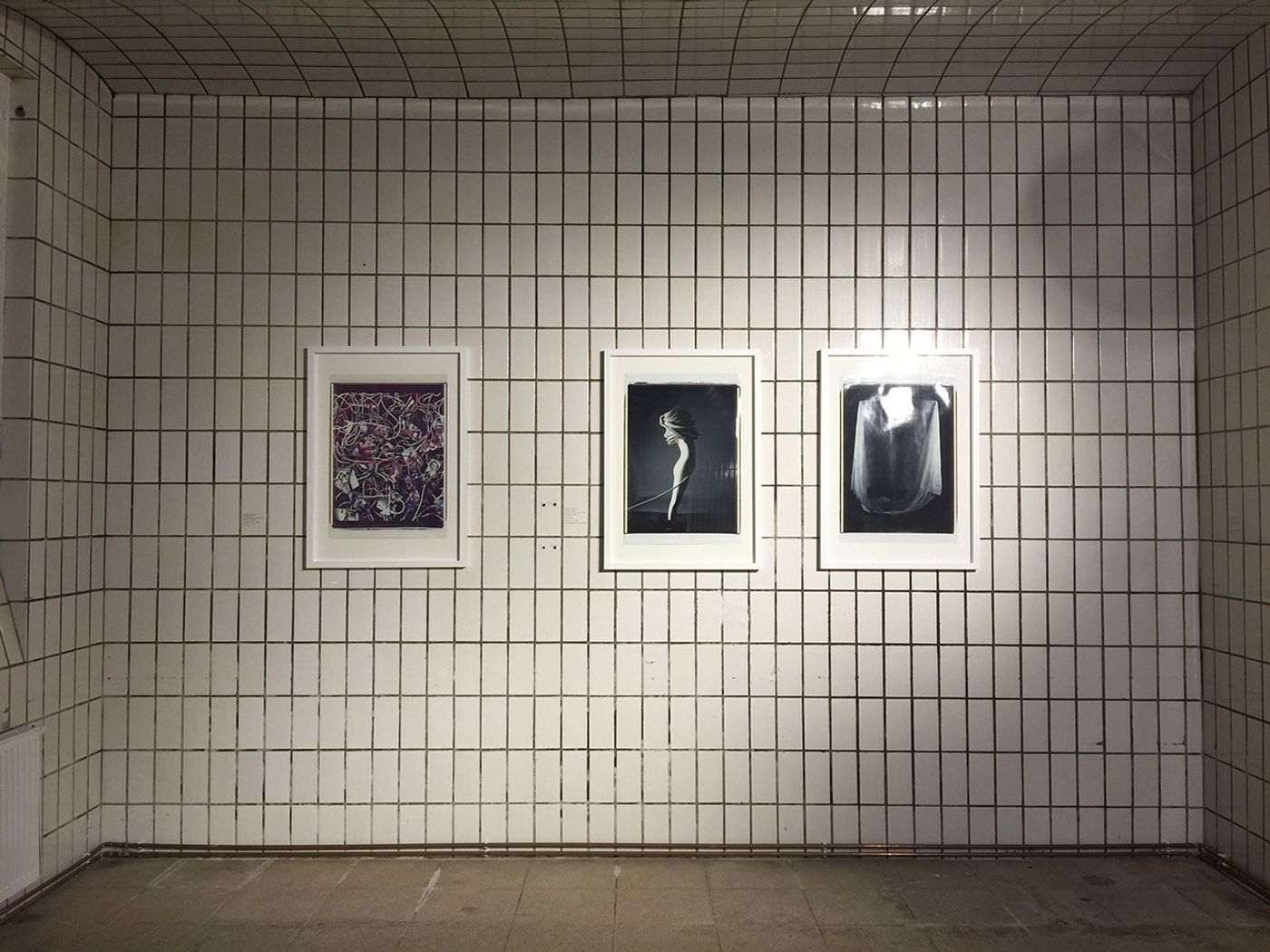 Installation View from Andrea Jünger Gallery during Open Gallery Night, Vienna Art Week 2016. The basement of Galerie Jünger is a former bakery, completely covered with white tiles. On the wall: photography by Werner Schnelle, from the series "Mise en Image", 1982-1986. Photo by Kiriakos Spirou. 