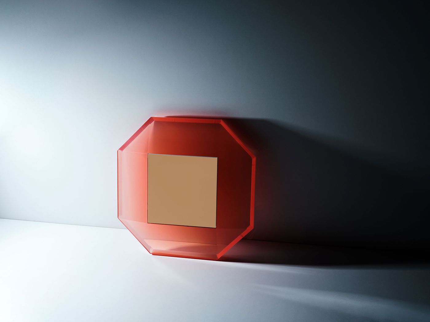 A geometric wall-mounted mirror with a translucent, glowing red octagonal frame and a central reflective square, casting dramatic shadows on a stark white surface—minimalist yet sculptural in presence. A geometric wall-mounted mirror with a translucent, glowing red octagonal frame and a central reflective square, casting dramatic shadows on a stark white surface—minimalist yet sculptural in presence.