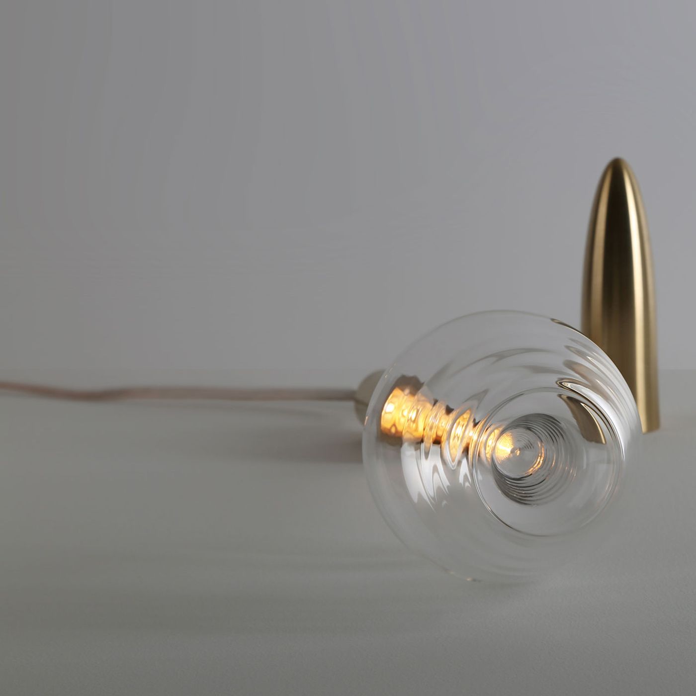Plugged table lamp by Lebanese interior architect and product designer Richard Yasmine. Made of solid brushed brass and a very thin hand blown borosilicate glass. Photo by BizarreBeirut.