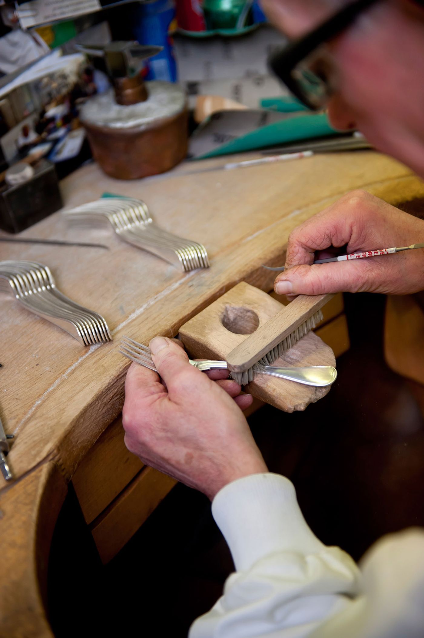 A silversmith working on a set of forks at the Puiforcat workshop. Photo by Alexandre &amp; Emilie {Persona production} for Yatzer. Copyright © Yatzerland Ltd.