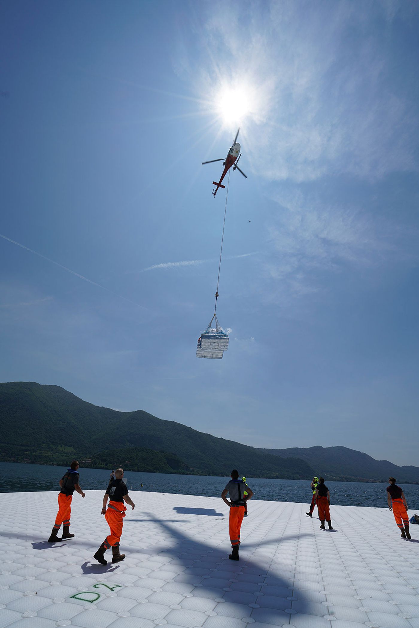 The felt that will cover the cubes underneath the yellow fabric is transported from Montecolino to San Paolo island by Elimast Helicopter Service, May 2016. Photo by Wolfgang Volz.